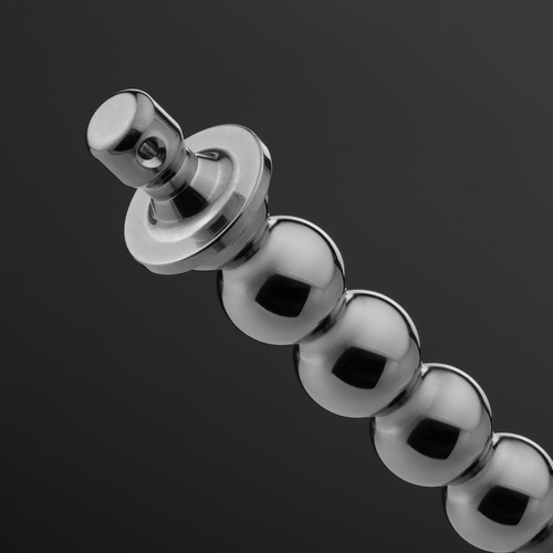 Macro view of a stainless steel beaded urethral sound base (Bubbles 11-13 mm), detailing the drilled cylindrical handle and largest metal spheres.
